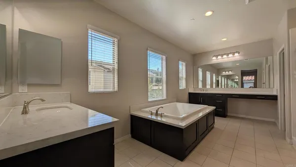 a white bath tub sitting in a bathroom next to a window
