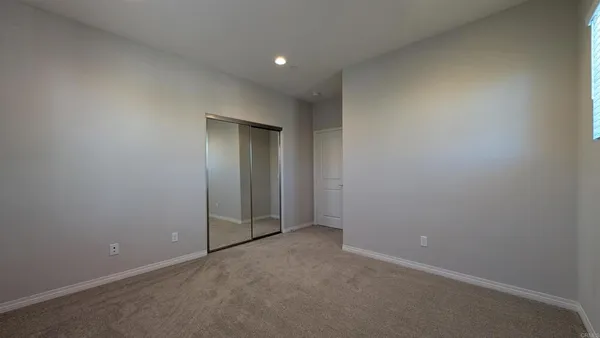 an empty room with windows and closet