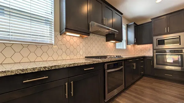 a kitchen with stainless steel appliances granite countertop a sink and a stove