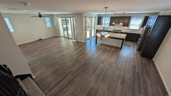 en empty room with windows and ceiling fan