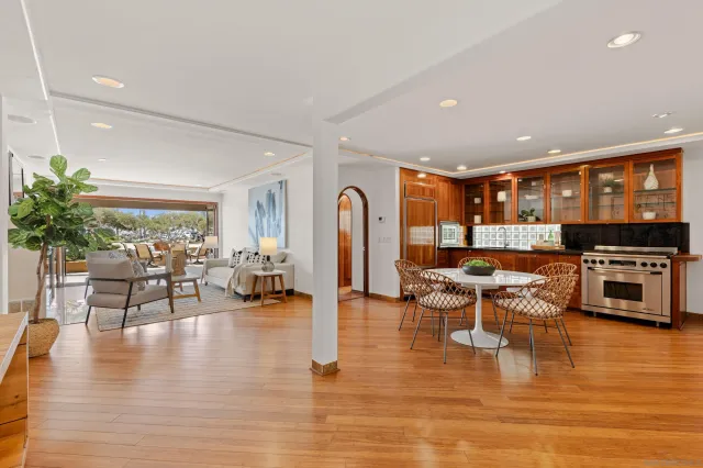 a kitchen with stainless steel appliances granite countertop a stove a sink a dining table and chairs