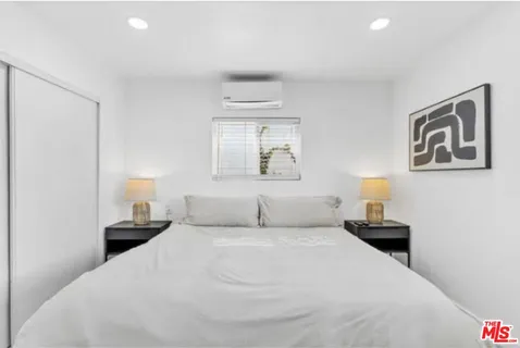 a bedroom with a bed and painting on the wall