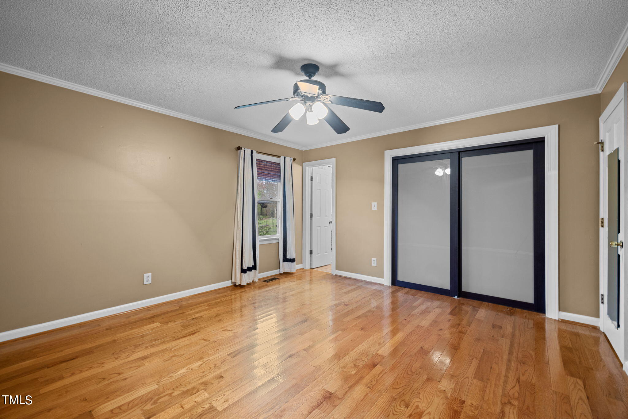 244 Ferrells Bridge Road Bunn, NC 27508 - Photo 13 of 36 a view of an empty room with window and wooden floor