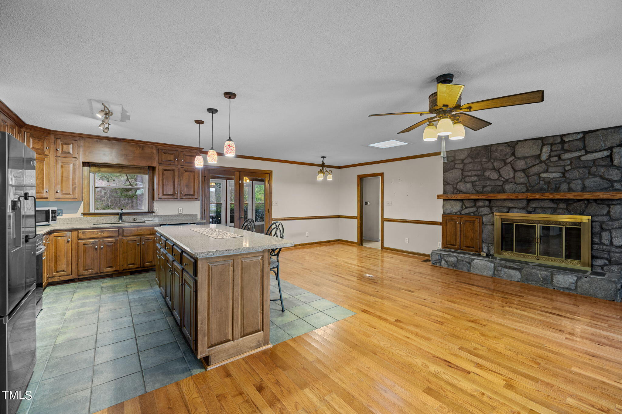 244 Ferrells Bridge Road Bunn, NC 27508 - Photo 5 of 36 a kitchen with stainless steel appliances granite countertop a stove a sink dishwasher a refrigerator and a fireplace with wooden floor