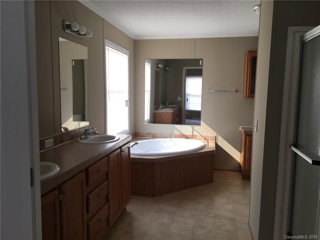 4860 Yoder Road Crouse, NC 28033 - Photo 15 of 20 a bathroom with a bathtub sink and mirror
