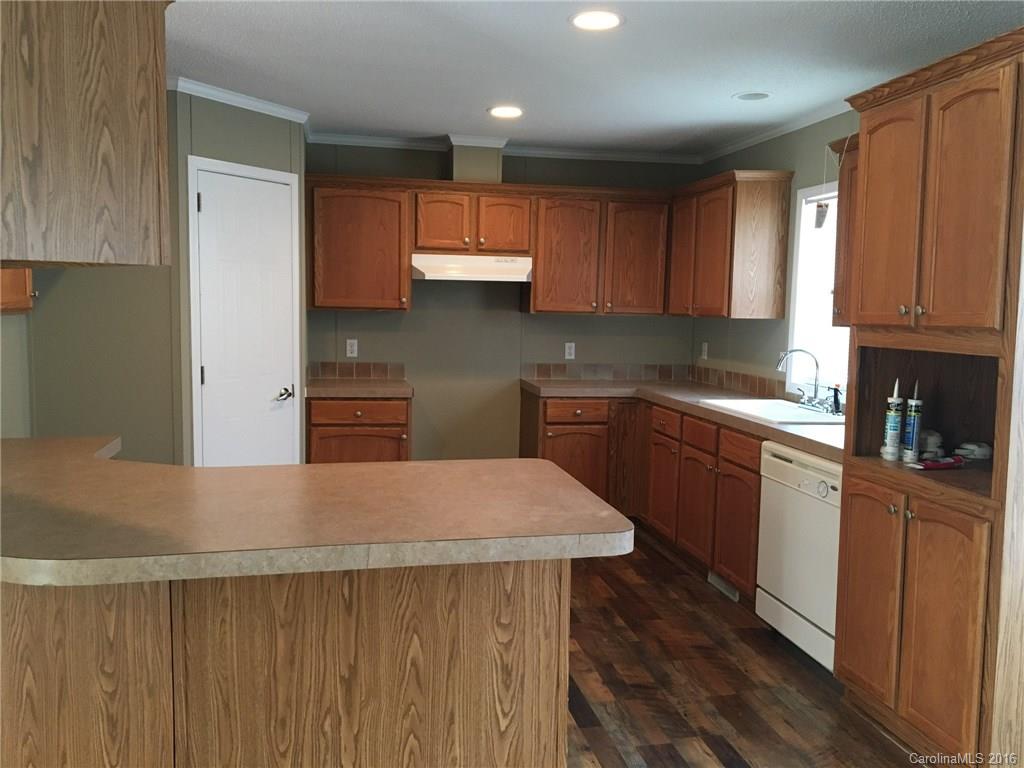 4860 Yoder Road Crouse, NC 28033 - Photo 8 of 20 a kitchen with kitchen island granite countertop wooden cabinets a sink and dishwasher