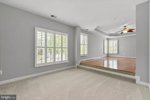 a view of a big room with window and a ceiling fan