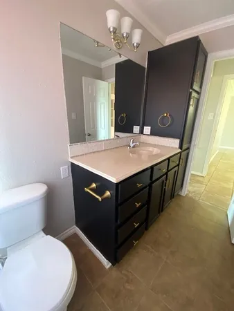 a spacious bathroom with a granite countertop sink a toilet a mirror and shower