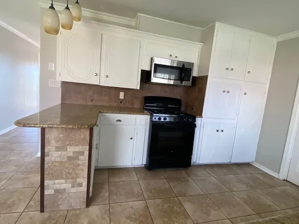 a kitchen with stainless steel appliances granite countertop a stove a sink and a refrigerator
