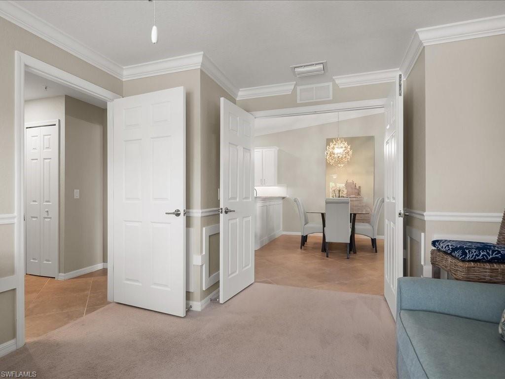 9532 Avellino Way, Unit 2726 Naples, FL 34113 - Photo 12 of 35 Corridor featuring light carpet, ornamental molding, a chandelier, and light tile patterned floors