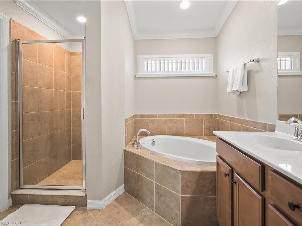 9532 Avellino Way, Unit 2726 Naples, FL 34113 - Photo 17 of 35 Full bathroom featuring a bath, a shower stall, vanity, crown molding, and light tile patterned flooring