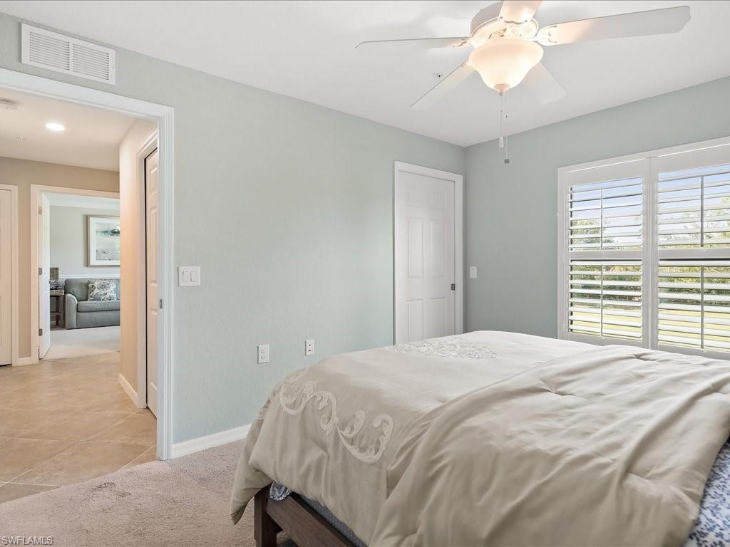 9532 Avellino Way, Unit 2726 Naples, FL 34113 - Photo 19 of 35 Bedroom with light carpet, a ceiling fan, and light tile patterned flooring