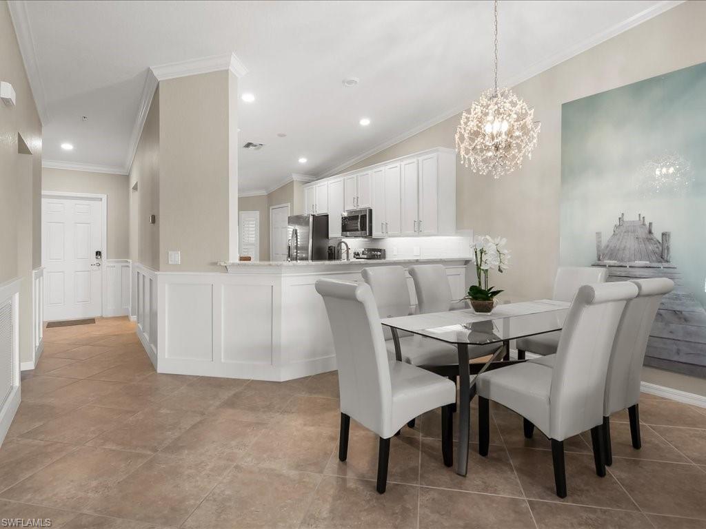 9532 Avellino Way, Unit 2726 Naples, FL 34113 - Photo 4 of 35 Dining area with wainscoting, a decorative wall, recessed lighting, a chandelier, and ornamental molding