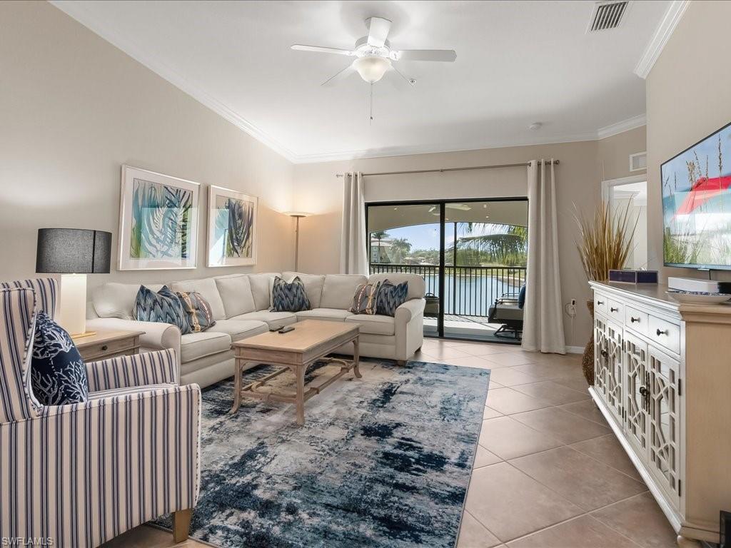 9532 Avellino Way, Unit 2726 Naples, FL 34113 - Photo 6 of 35 Living room with crown molding, light tile patterned floors, and a ceiling fan