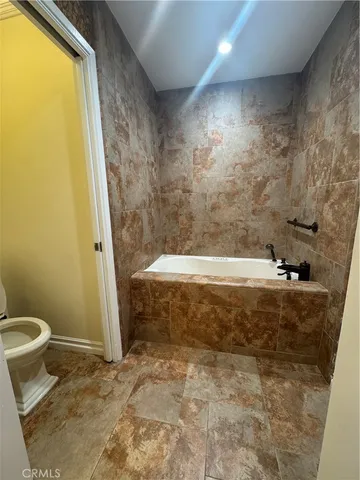 a bathroom with a tub and toilet