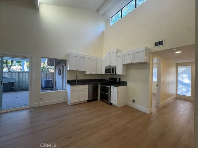 a kitchen with stainless steel appliances kitchen island granite countertop a refrigerator and a stove top oven