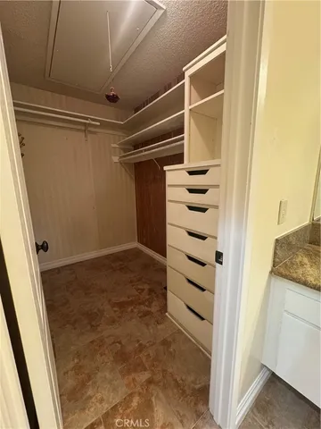 a view of walk in closet with empty racks