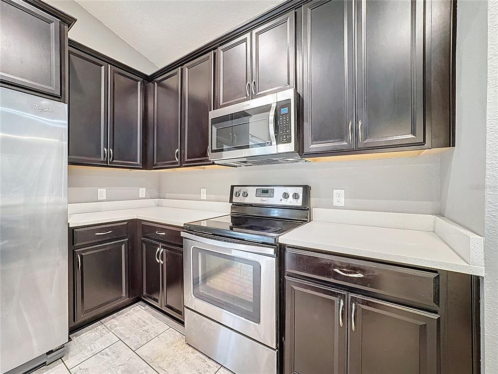 3477 Middlebrook Place Harmony, FL 34773 - Photo 28 of 78 a kitchen with granite countertop cabinets stainless steel appliances and a sink