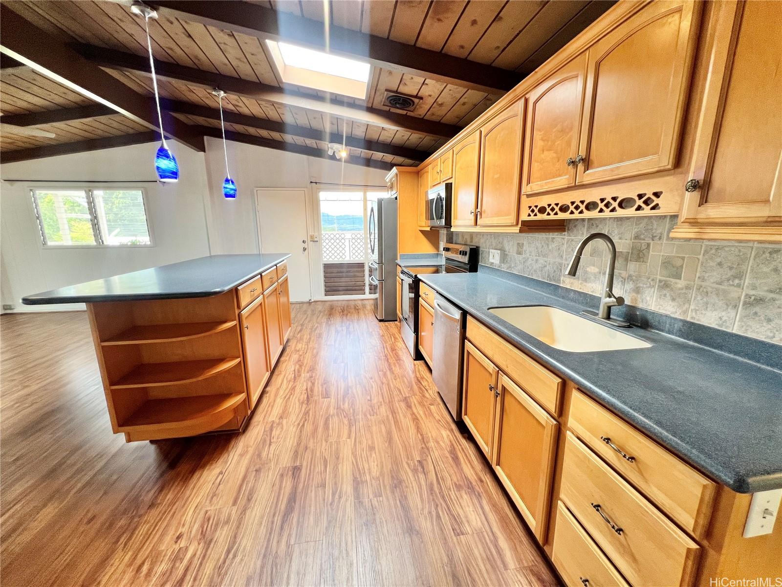 2407 Komo Mai Drive Pearl City, HI 96782 - Photo 3 of 25 a kitchen with stainless steel appliances granite countertop a sink and wooden floors