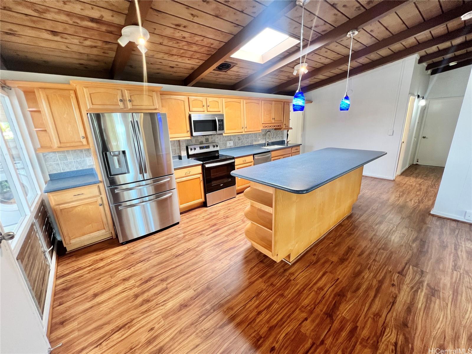 2407 Komo Mai Drive Pearl City, HI 96782 - Photo 5 of 25 a kitchen with stainless steel appliances wooden floors and a stove