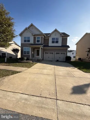a view of a big house with wooden fence