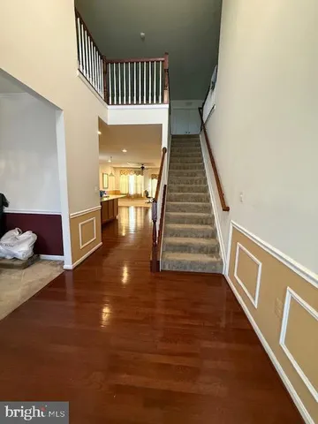 a view of a hallway with wooden floor and staircase
