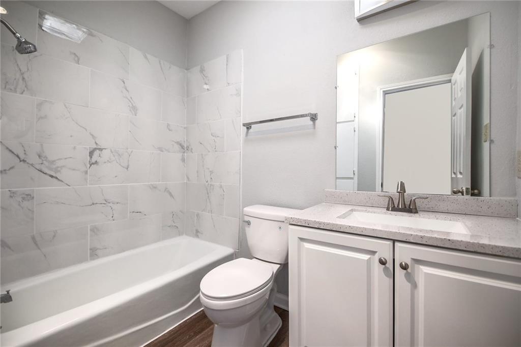 2529 Rio Grande Street, Unit 93 Austin, TX 78705 - Photo 11 of 19 The bathroom features a bathtub with white subway tile surround, a toilet, and a vanity with a white countertop and white cabinetry