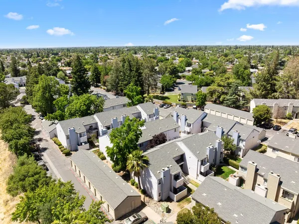 an aerial view of a house with lots of residential buildings ocean and mountain view in back