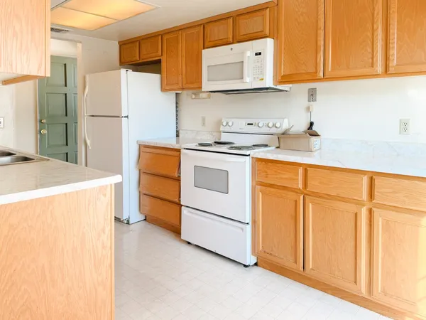 a kitchen with stainless steel appliances granite countertop a refrigerator sink and white cabinets
