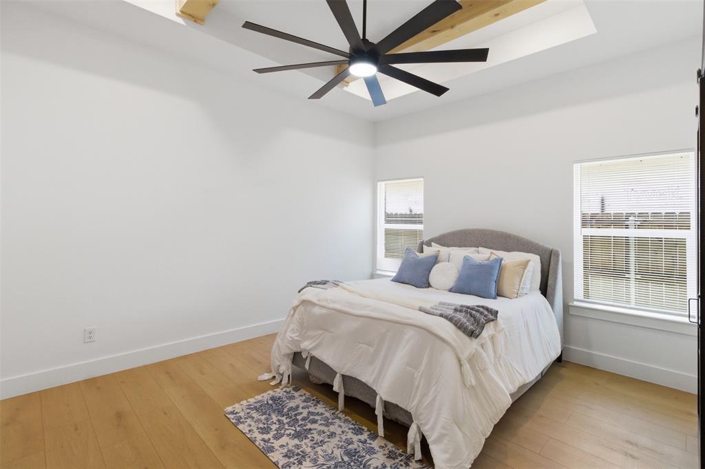 435 Waterboard Road Trinidad, TX 75163 - Photo 26 of 39 Room featuring a tray ceiling with exposed wood beams, a contemporary ceiling fan, wood-finish flooring, and multiple windows