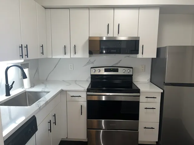 a kitchen with stainless steel appliances granite countertop a sink stove and microwave
