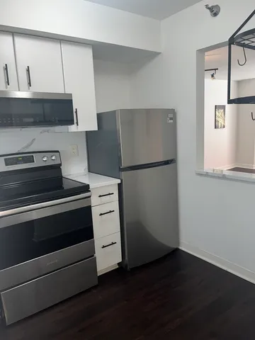 a bedroom with a bed a dresser next to a window
