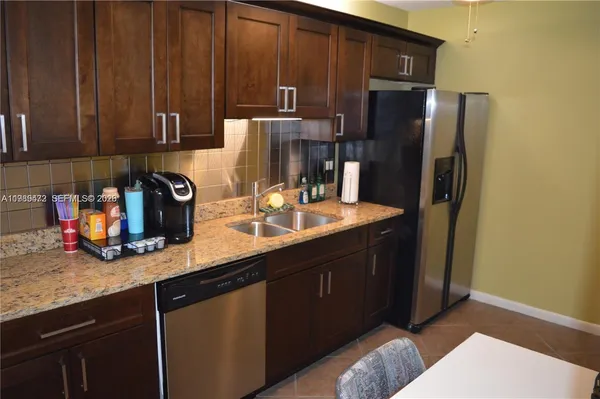 a kitchen with stainless steel appliances granite countertop a refrigerator and a sink