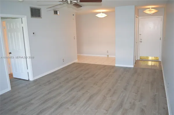 an empty room with wooden floor and entrance