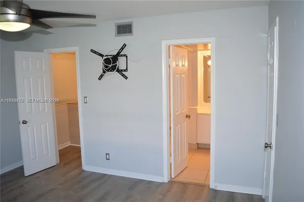 an entryway to room with wooden floor and a window