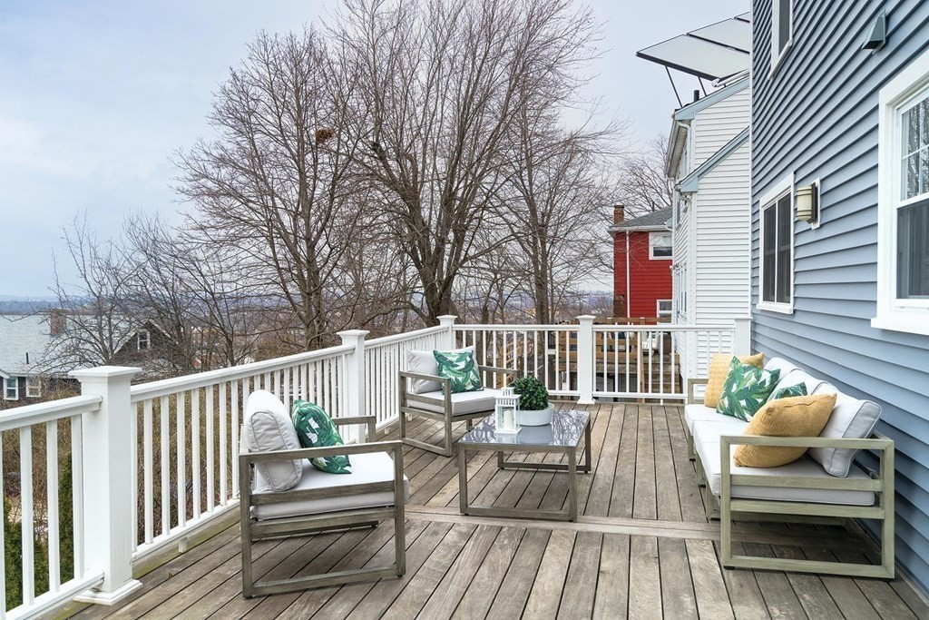 10 Jenness Road Brookline, MA 02446 - Photo 16 of 20 a view of a deck with couches table and chairs and wooden floor