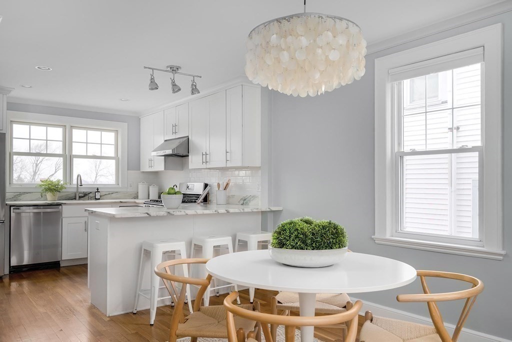 10 Jenness Road Brookline, MA 02446 - Photo 4 of 20 a kitchen with stainless steel appliances kitchen island granite countertop a sink a stove a dining table and chairs