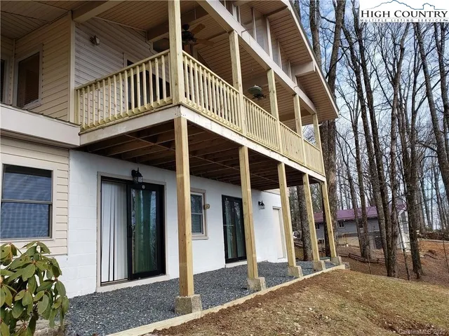 a view of a patio with table and chairs with wooden floor and fence