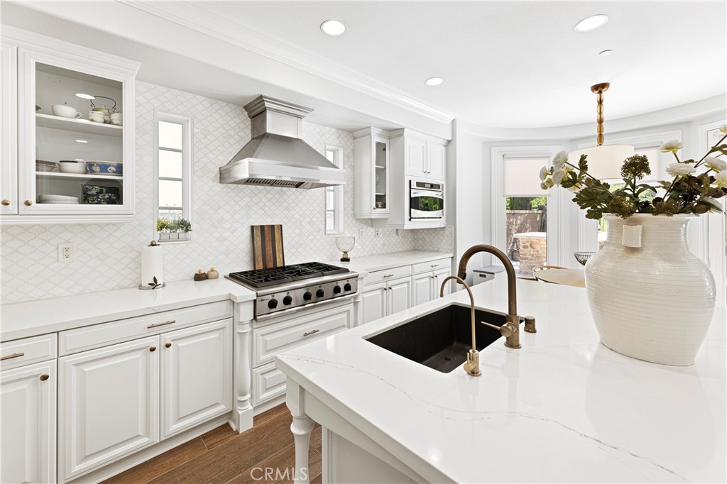 54 Valley Terrace Irvine, CA 92603 - Photo 26 of 60 a kitchen with white cabinets a sink dishwasher and a stove
