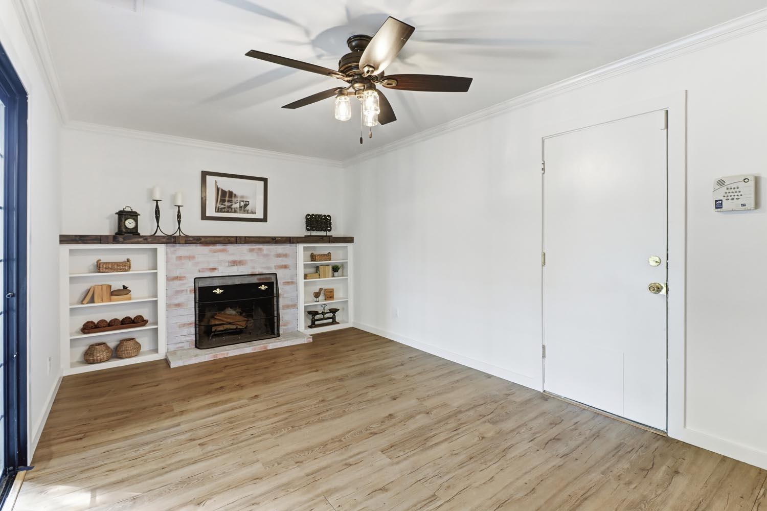 1224 Spruce Lane Davis, CA 95616 - Photo 16 of 49 a view of a livingroom with a fireplace a ceiling fan and wooden floor