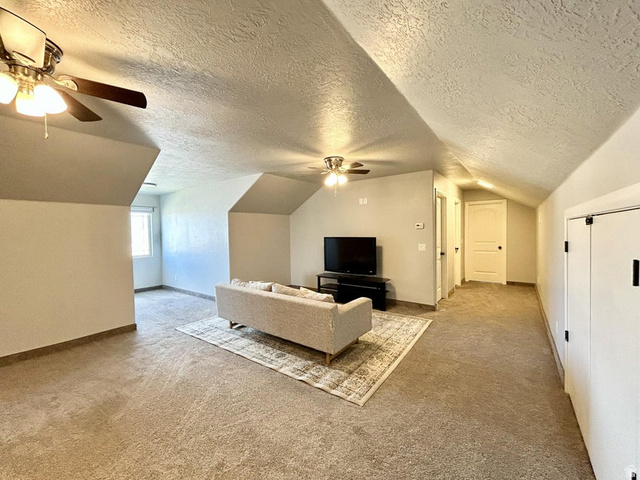 310 625 East Enterprise, UT 84725 - Photo 26 of 36 Expansive carpeted room featuring vaulted ceilings, recessed window, and ceiling fans