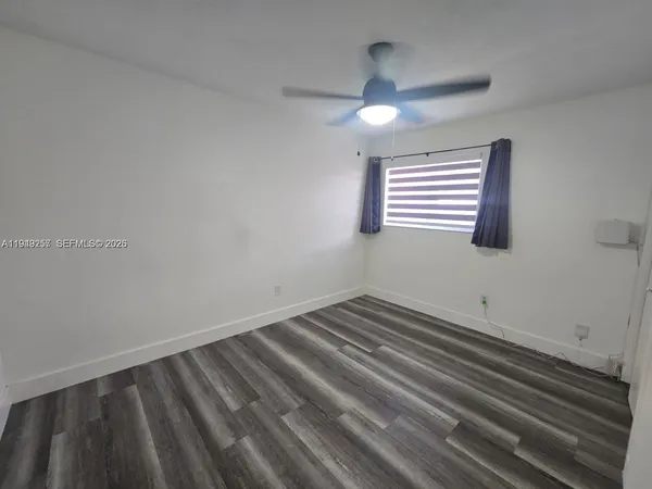 a view of an empty room and window ceiling fan
