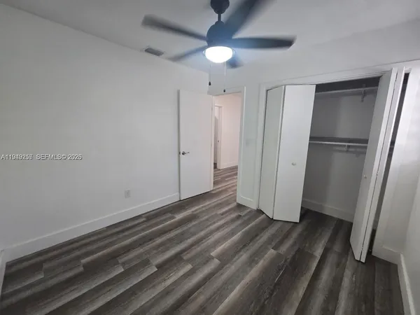 a view of empty room with wooden floor