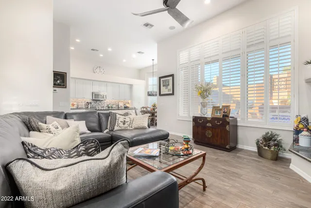 a living room with furniture kitchen view and a large window