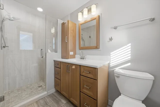 a bathroom with a sink toilet vanity and shower