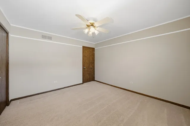 an empty room with a ceiling fan and a window