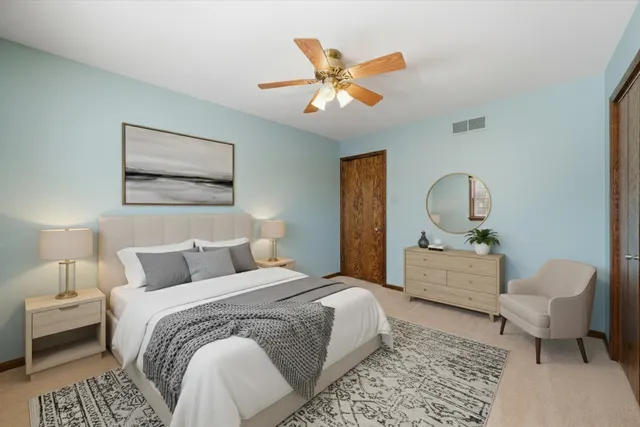 a bedroom with a large bed and a chandelier