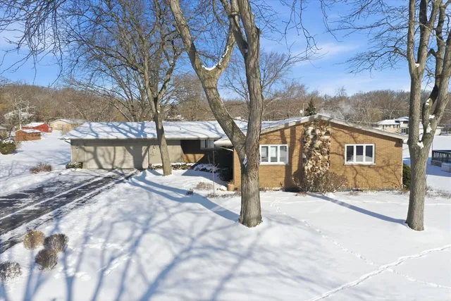 a view of a house with a yard covered in snow