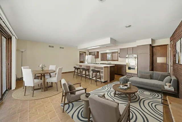 a living room with furniture and a dining table with kitchen view