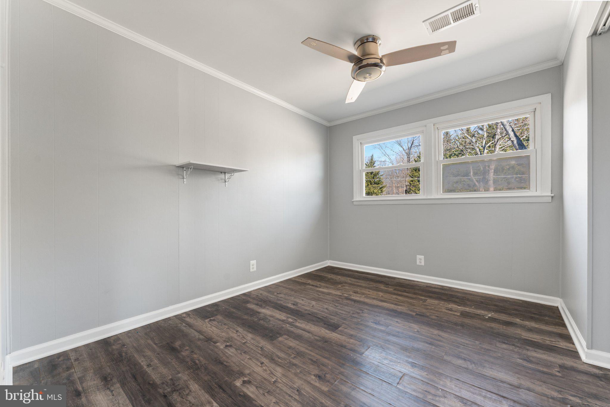 15307 Thoroughfare Road Gainesville, VA 20155 - Photo 21 of 38 an empty room with wooden floor ceiling fan and windows